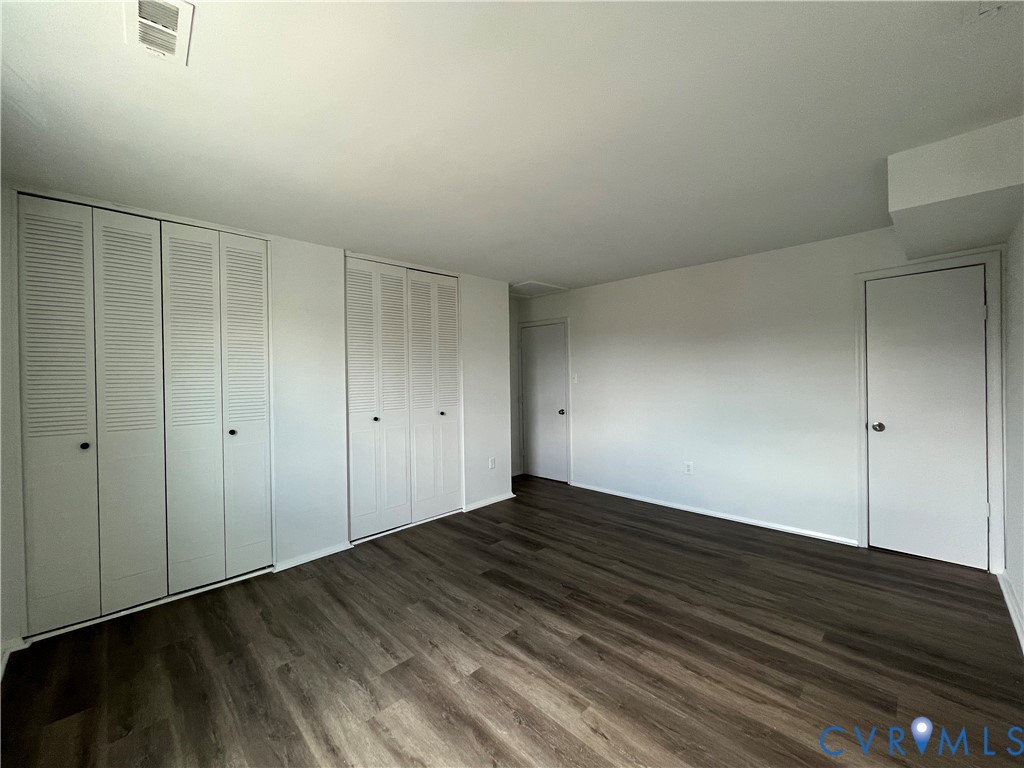 Wood-finish flooring, dual sets of bi-fold closet doors, and neutral wall tones