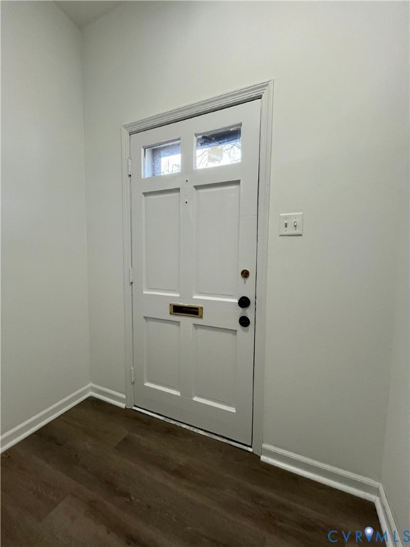 Entryway featuring a white paneled door with dual glass lites, brass mail slot, and matte black hardware, finished with wood-finish flooring