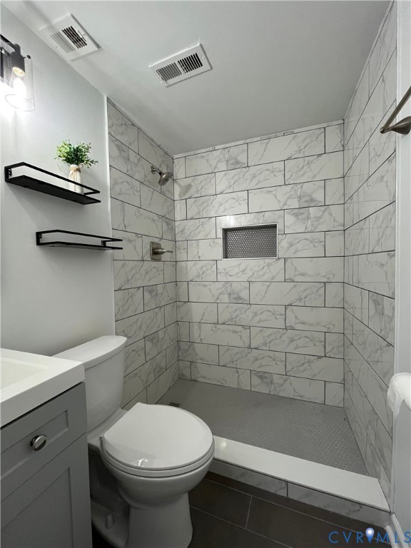 Walk-in shower featuring large-format stone-look wall tiling, a built-in recessed niche, and a tiled floor, accented by a grey vanity cabinet and metal wall-mounted shelving