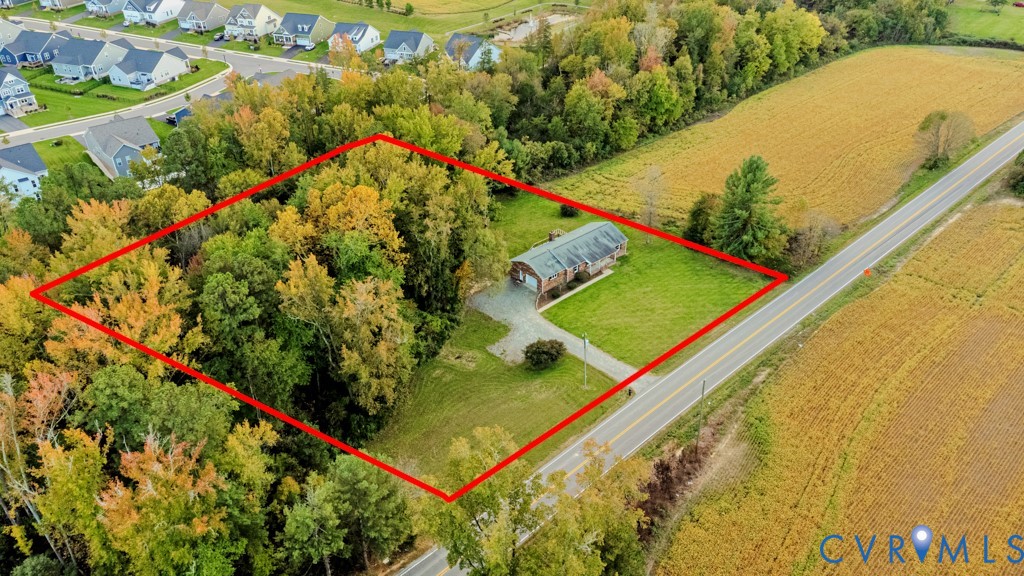 Expansive parcel featuring mature trees, manicured lawn, and a paved driveway Expansive parcel featuring mature trees, manicured lawn, and a paved driveway