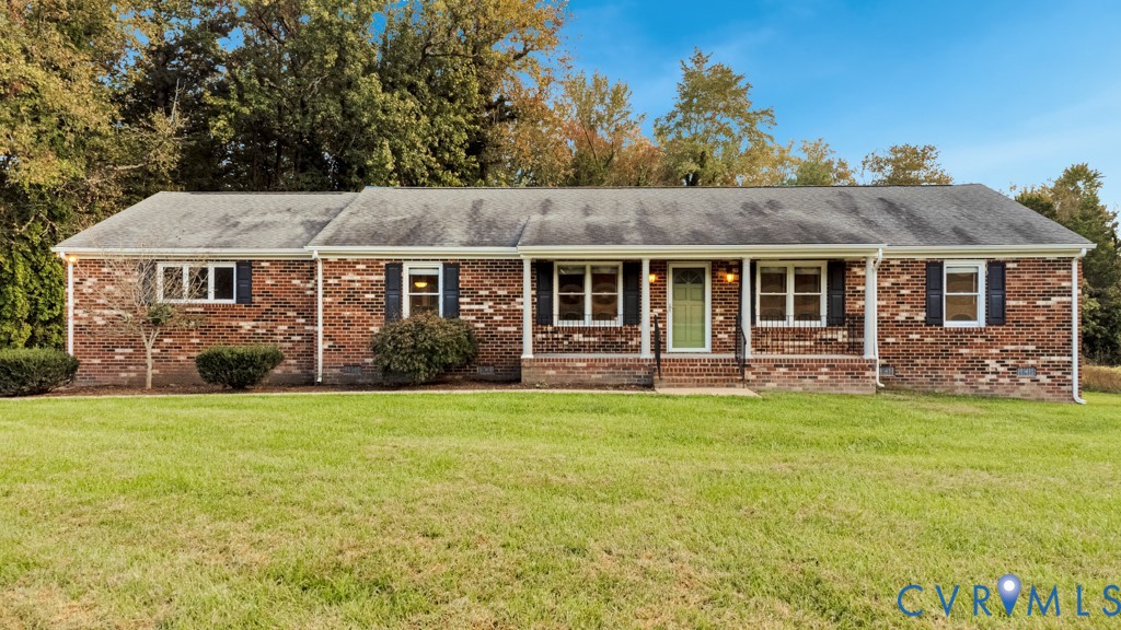 Single-story brick exterior featuring a covered front porch, wrought iron railings, multi-pane windows with shutters, and expansive lawn frontage Single-story brick exterior featuring a covered front porch, wrought iron railings, multi-pane windows with shutters, and expansive lawn frontage