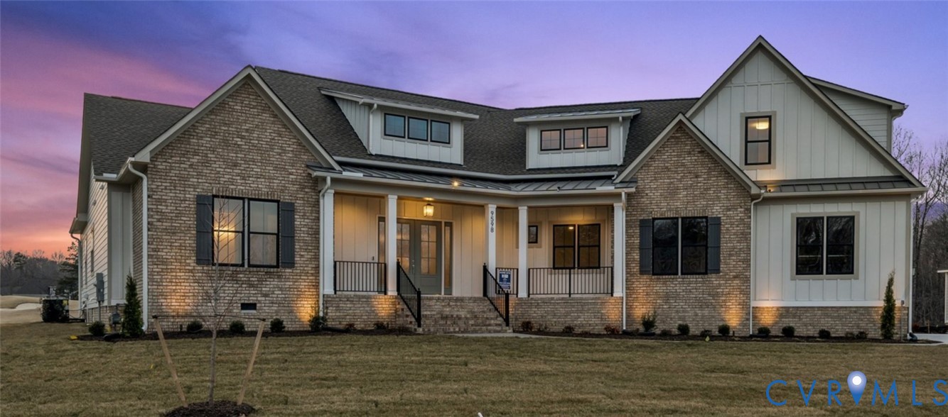 Multi-gabled exterior featuring stone masonry, vertical board-and-batten siding, a covered front porch, and black metal railings
