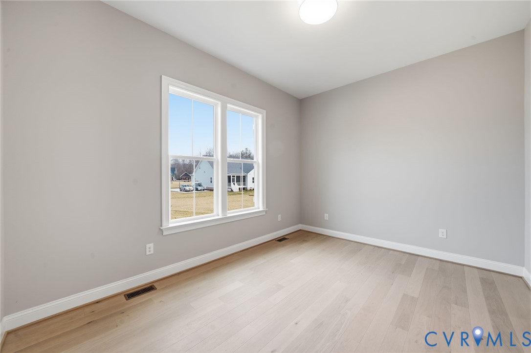 Room featuring neutral-toned walls, wood-finish flooring, and a dual-pane window
