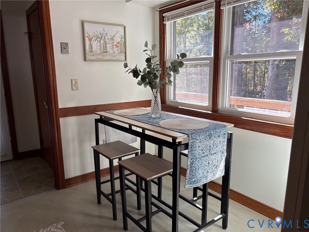 Double-hung windows with natural wood trim, chair rail molding, and neutral floor covering
