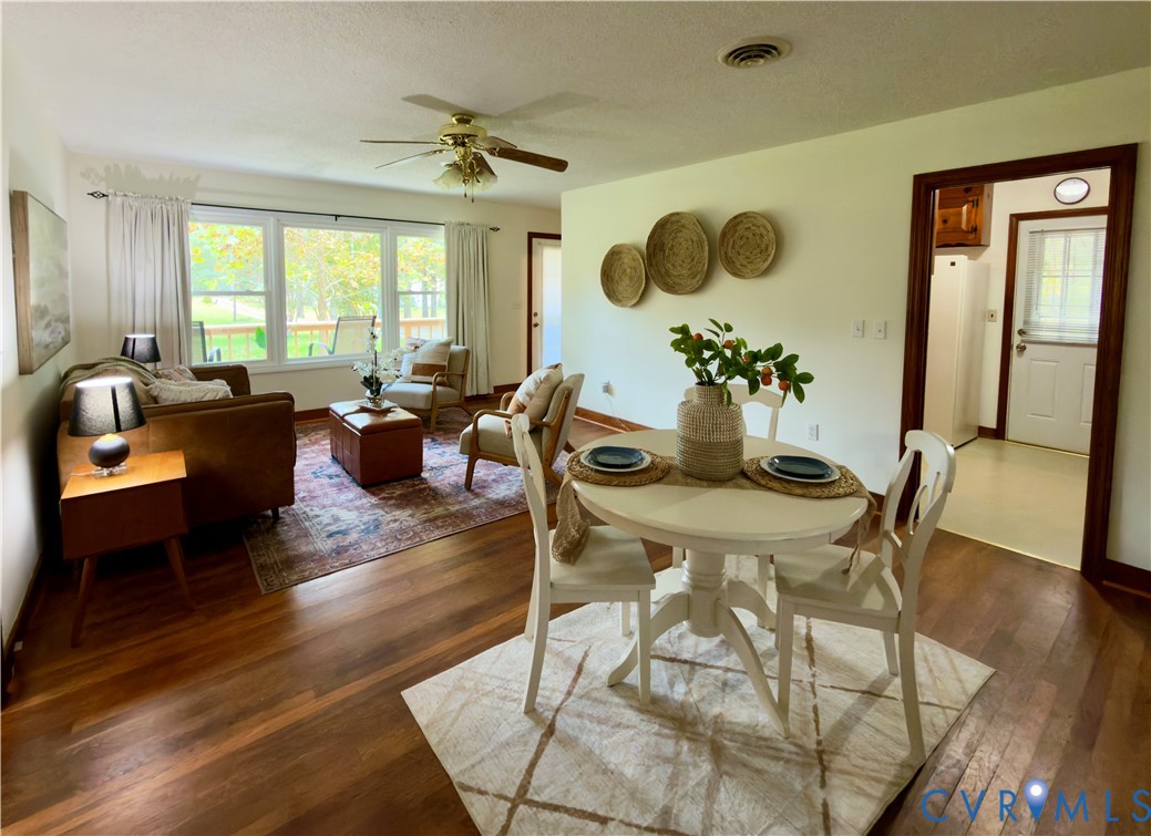 Wood-finish flooring, multi-pane windows with exterior natural light, and a ceiling fan with integrated lighting