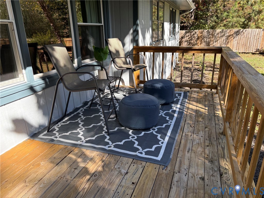 Elevated wood deck featuring a wooden railing and vertical siding exterior