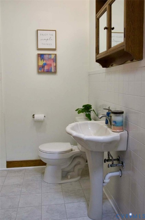 Ceramic pedestal sink, wall-mounted wood-finish medicine cabinet, ceramic wall tiling, and tile flooring