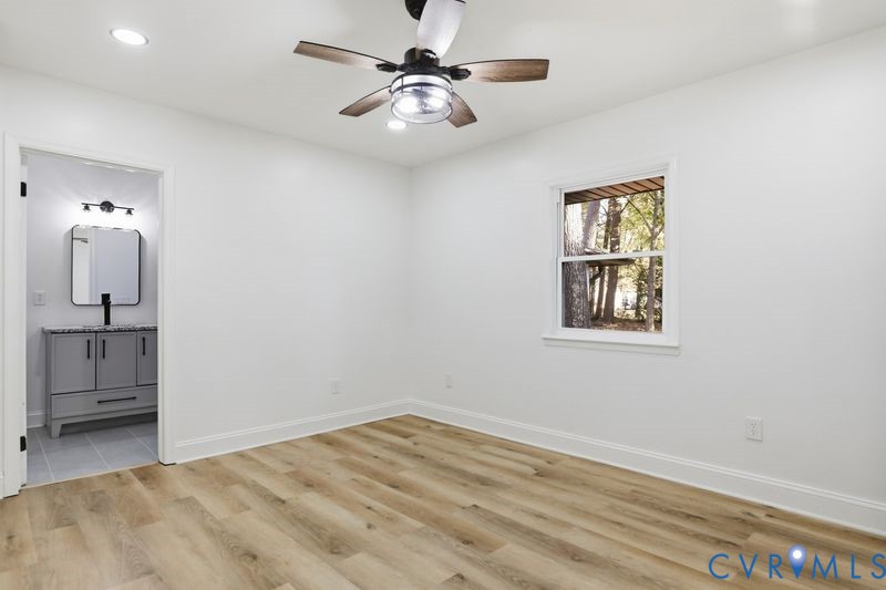 Interior space featuring wood-finish flooring, a ceiling fan with integrated lighting, recessed lighting, and a single-hung window