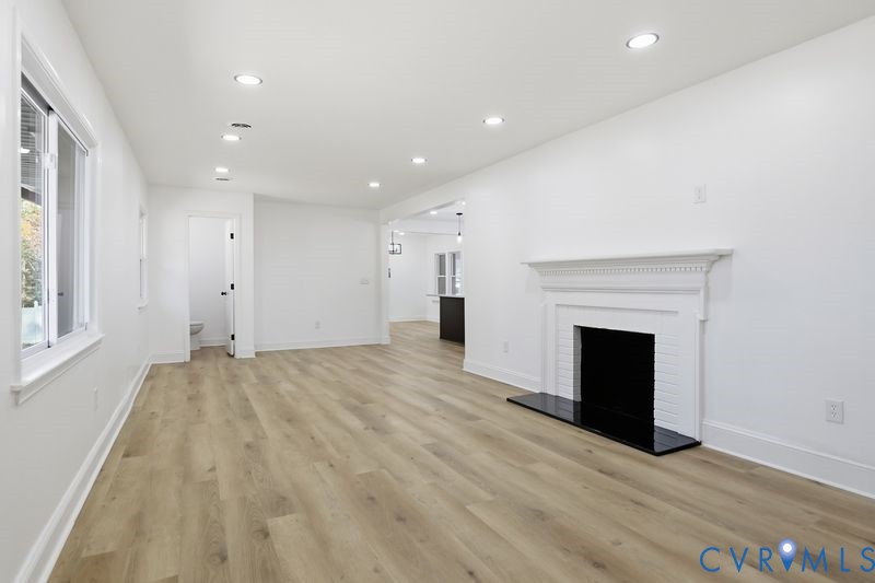 Interior featuring wood-finish flooring, recessed lighting, and a white fireplace mantel with a black hearth