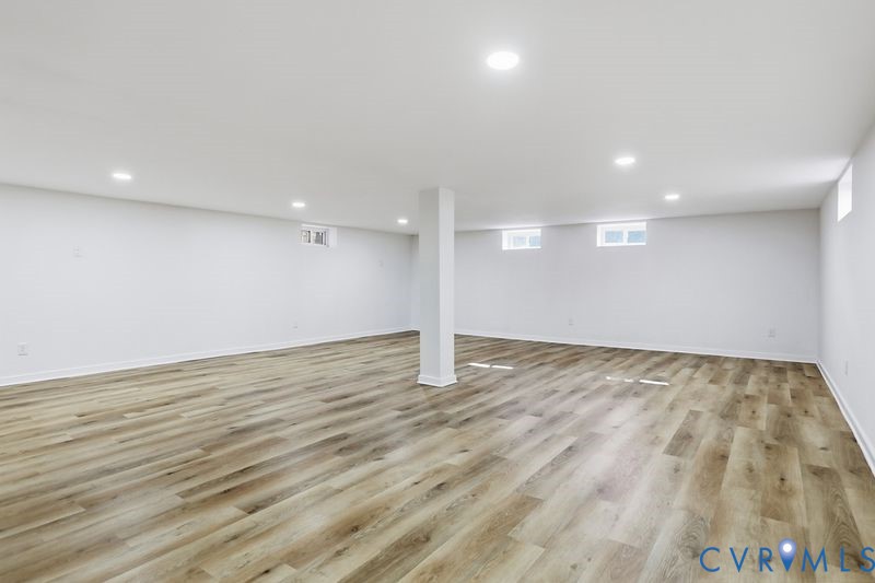 Open-concept interior featuring wood-finish flooring, recessed lighting, and multiple horizontal windows