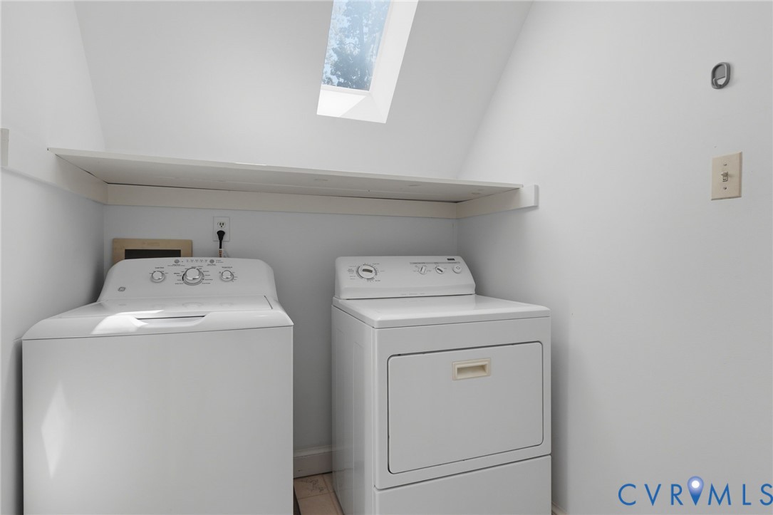 Laundry area featuring a skylight and integrated full-width shelving