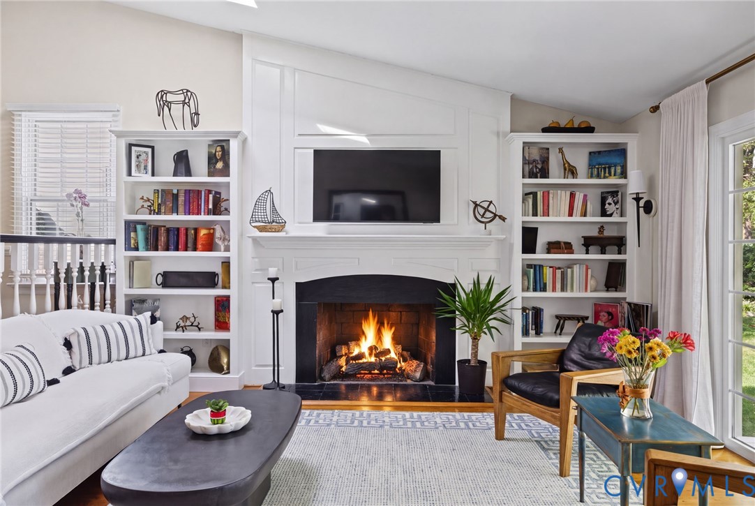 Fireplace with a black surround and mantel, flanked by floor-to-ceiling built-in cabinetry with integrated shelving
