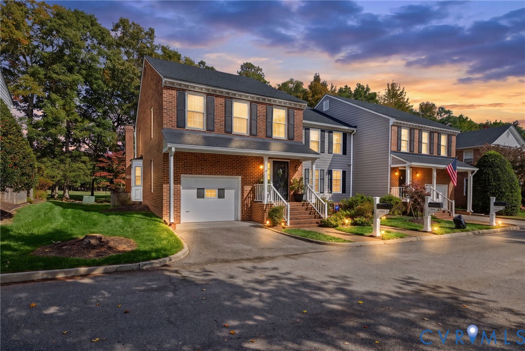 Two-story exterior featuring a brick facade with horizontal siding, an integrated single-car garage, shuttered windows, and a covered front entryway with stairs Two-story exterior featuring a brick facade with horizontal siding, an integrated single-car garage, shuttered windows, and a covered front entryway with stairs