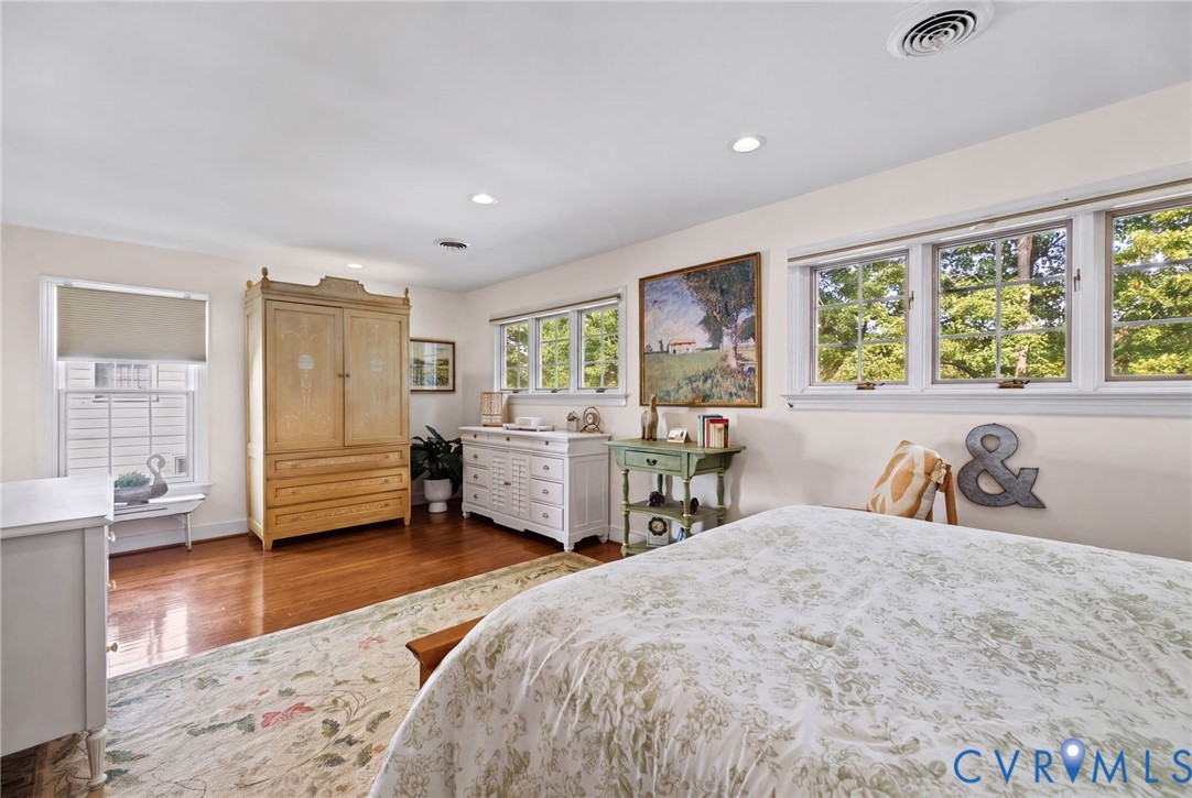 Bedroom featuring wood-finish flooring, multi-pane windows, and recessed lighting