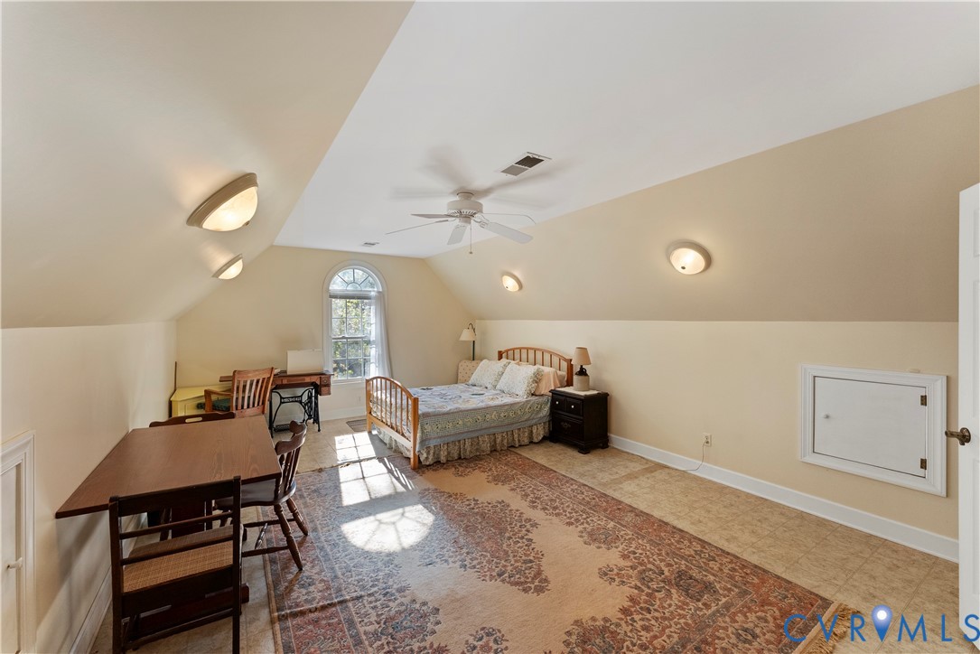 Vaulted ceilings, arched window, ceiling fan, and built-in access panel