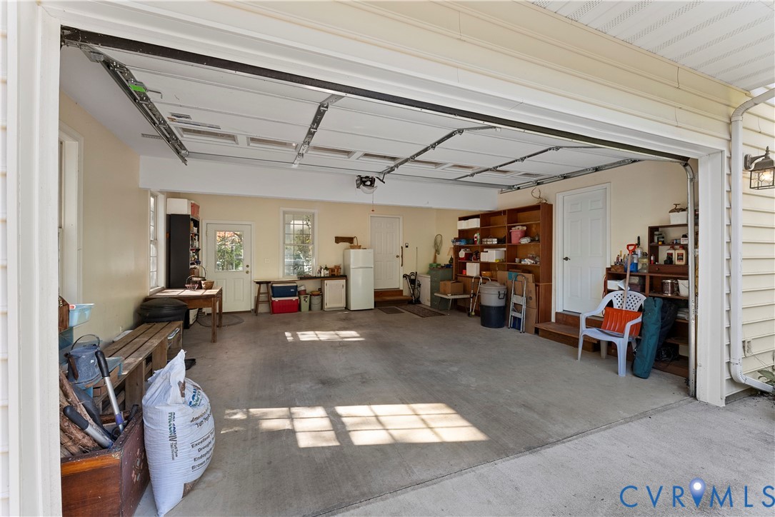 Attached two-car garage featuring a concrete floor, two entry doors, and multi-paned windows