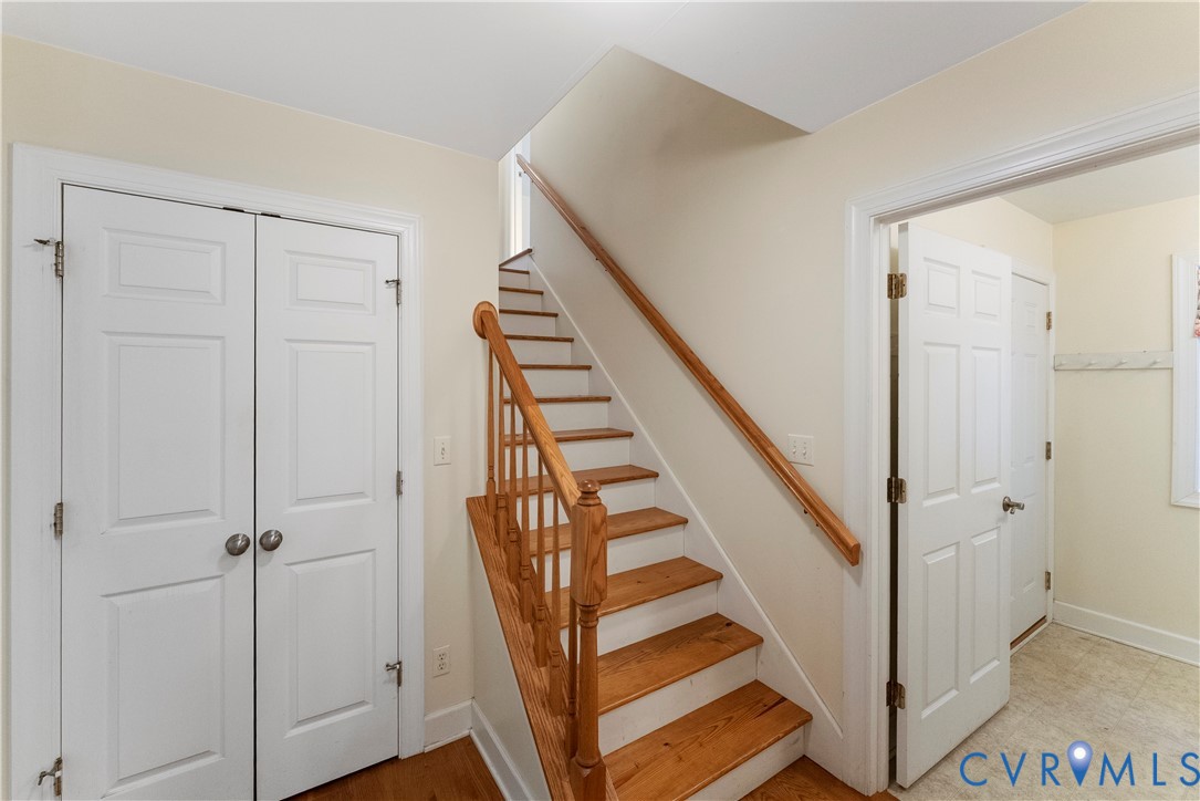 Staircase featuring natural wood-finish treads, a matching handrail, and traditional wood balusters, complemented by six-panel interior doors
