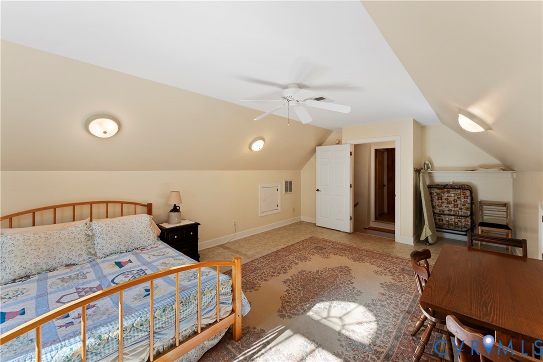 Vaulted ceilings featuring a white ceiling fan, recessed wall lighting, and access door to attic storage