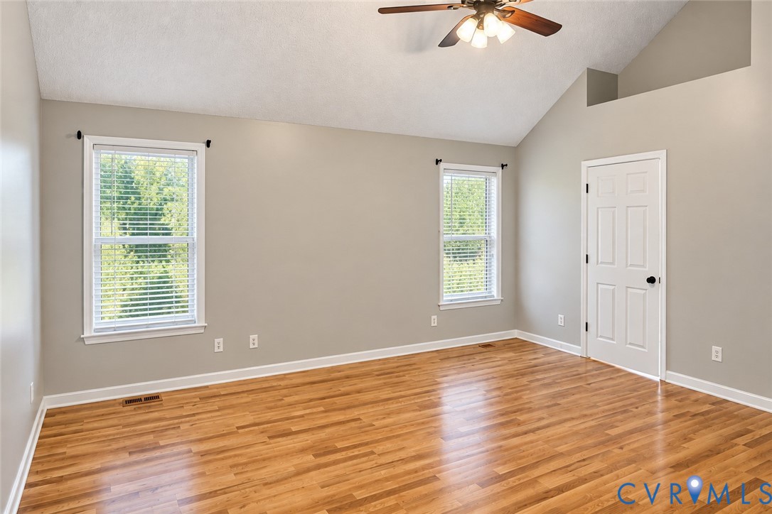 Vaulted ceilings, wood-finish flooring, two dual-pane windows, and a ceiling-mounted light fixture