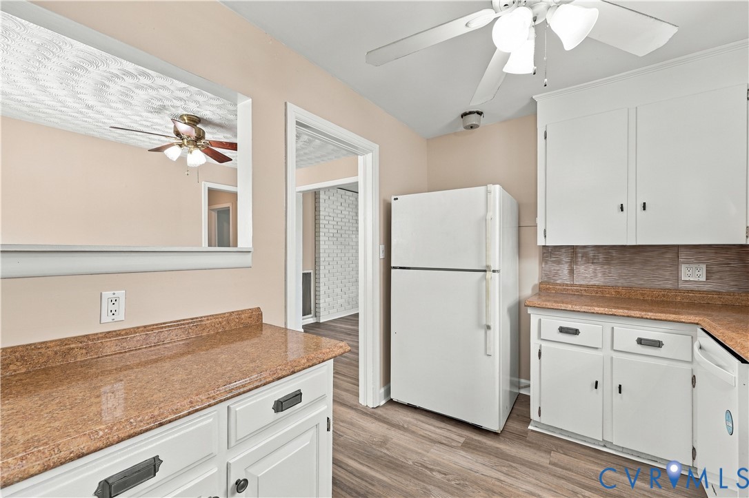 Kitchen featuring white cabinetry, stone-finish countertops, wood-finish flooring, a wall-mounted mirror, and a ceiling fan with integrated lighting