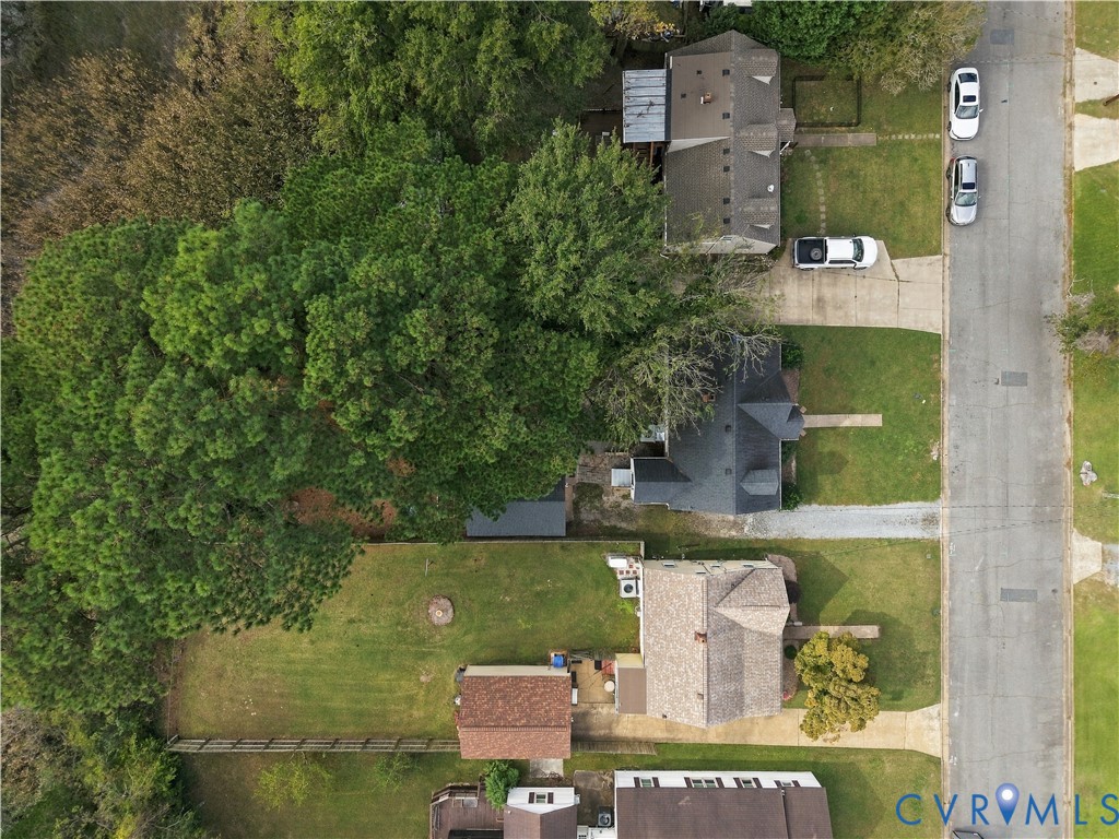 Aerial perspective featuring a spacious lot with a sprawling lawn, mature trees, and a detached structure