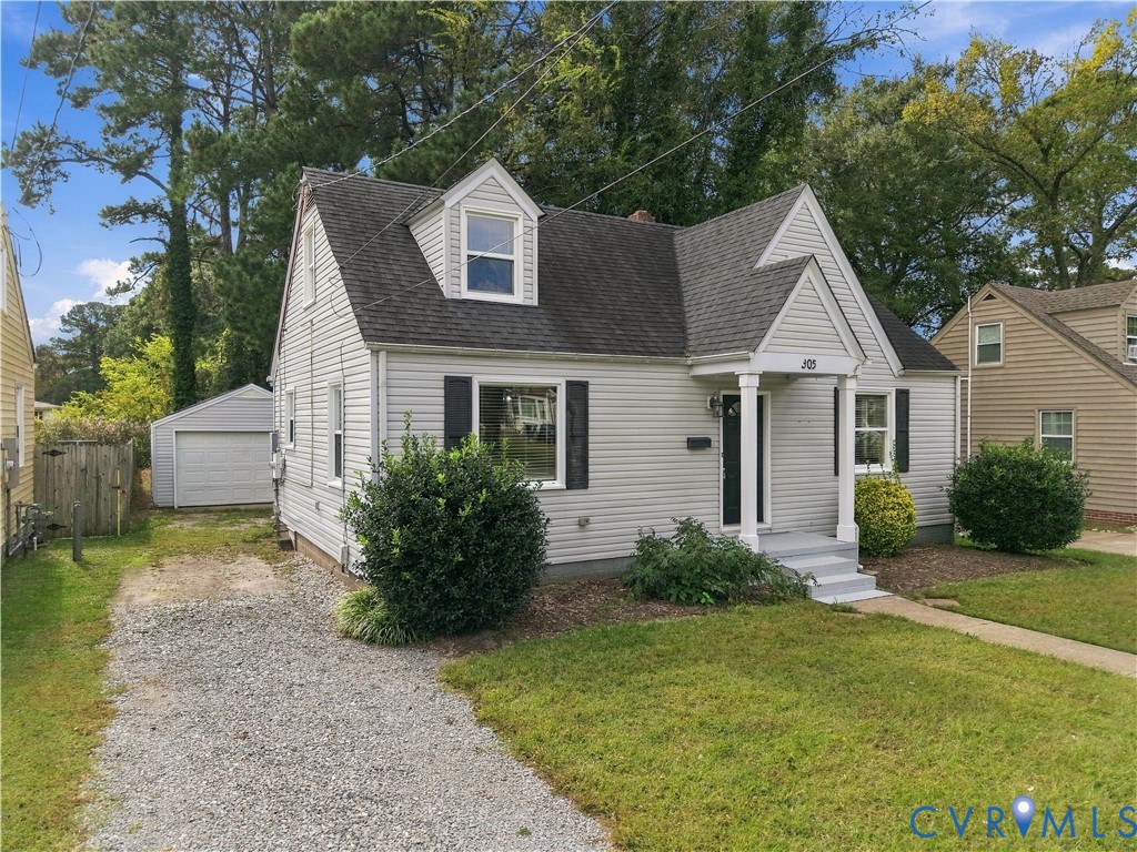 Cape Cod style exterior featuring horizontal siding, a gabled roofline, dormer window, covered front stoop with column support, and a detached single-car garage