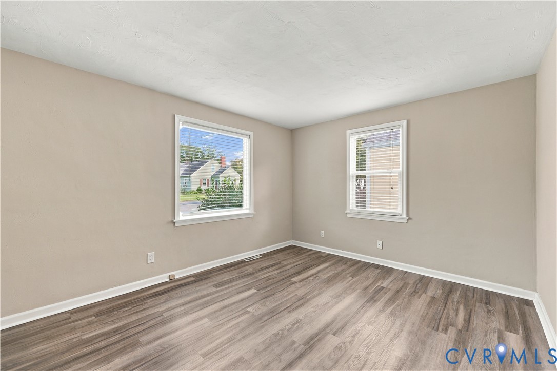 Neutral-toned walls, wood-finish flooring, and two double-hung windows