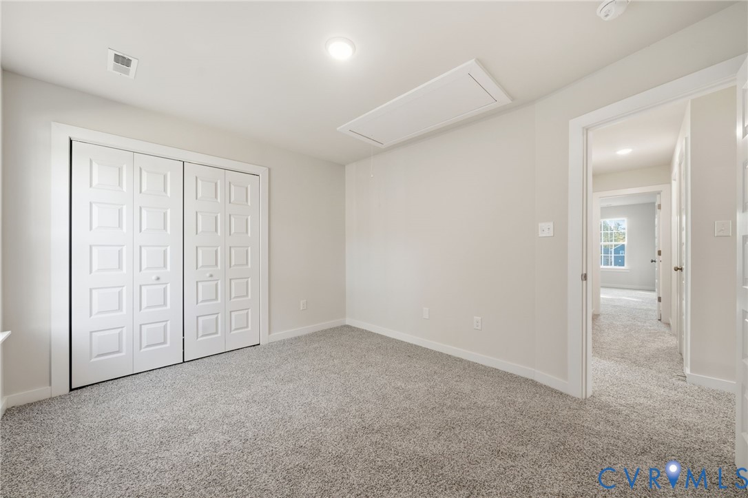 Neutral interior featuring plush wall-to-wall carpeting, recessed ceiling lighting, and a double-door closet with square-paneled detailing