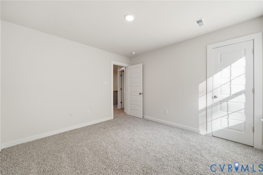 Neutral-toned wall paint, plush carpeting, recessed lighting, and multi-panel interior doors