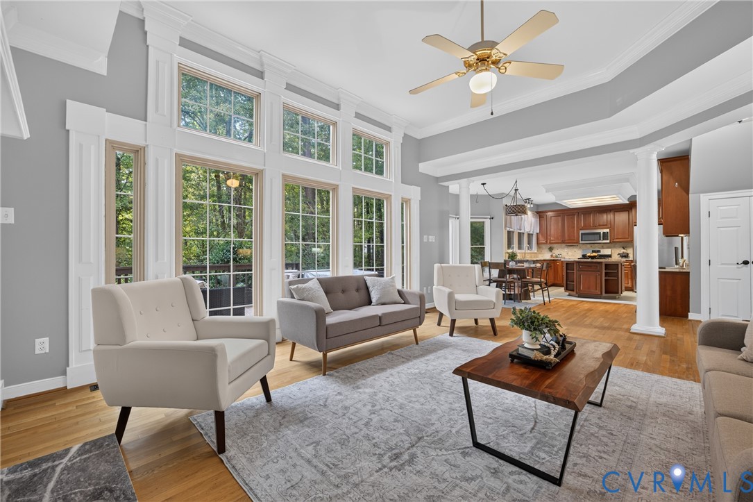 Vaulted ceilings with crown molding, floor-to-ceiling windows with mullions, wood-finish flooring, and classical architectural columns Vaulted ceilings with crown molding, floor-to-ceiling windows with mullions, wood-finish flooring, and classical architectural columns