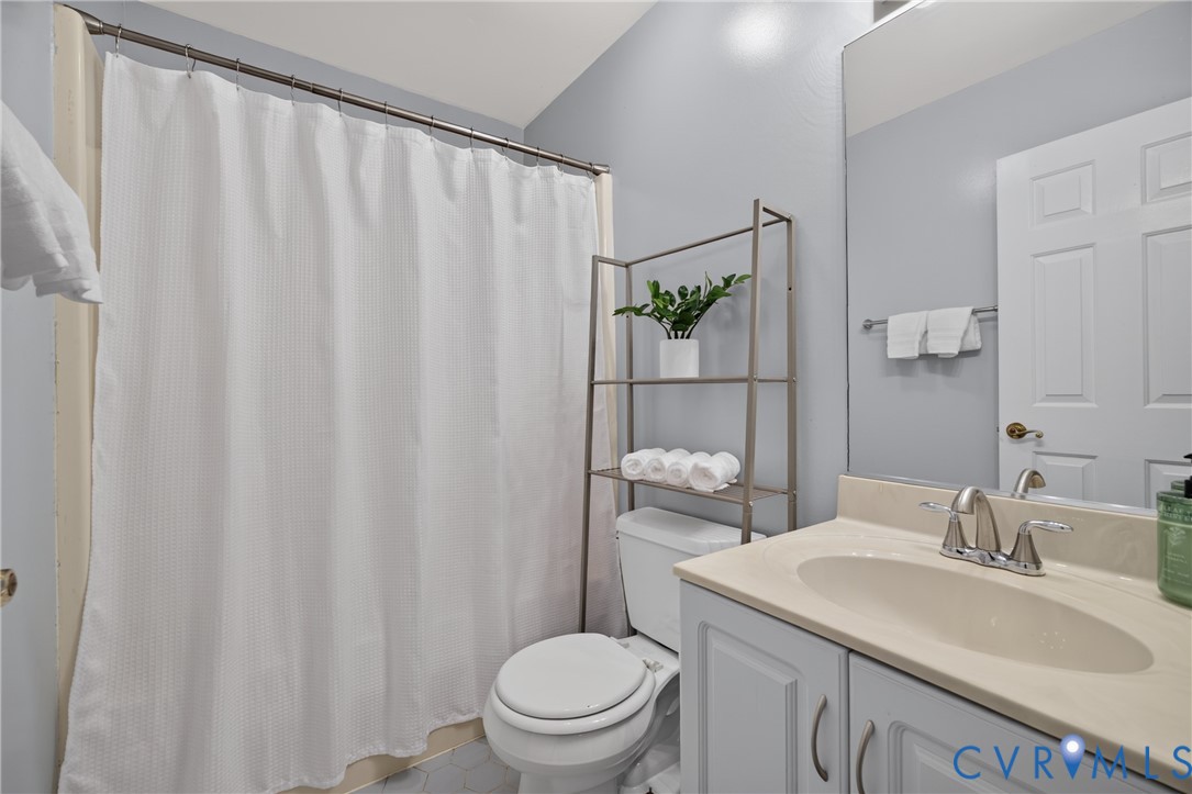 Bathroom featuring a vanity with a neutral-tone countertop, an integrated oval basin, a large wall-mounted mirror, and a shower-tub combination with an overhead rod