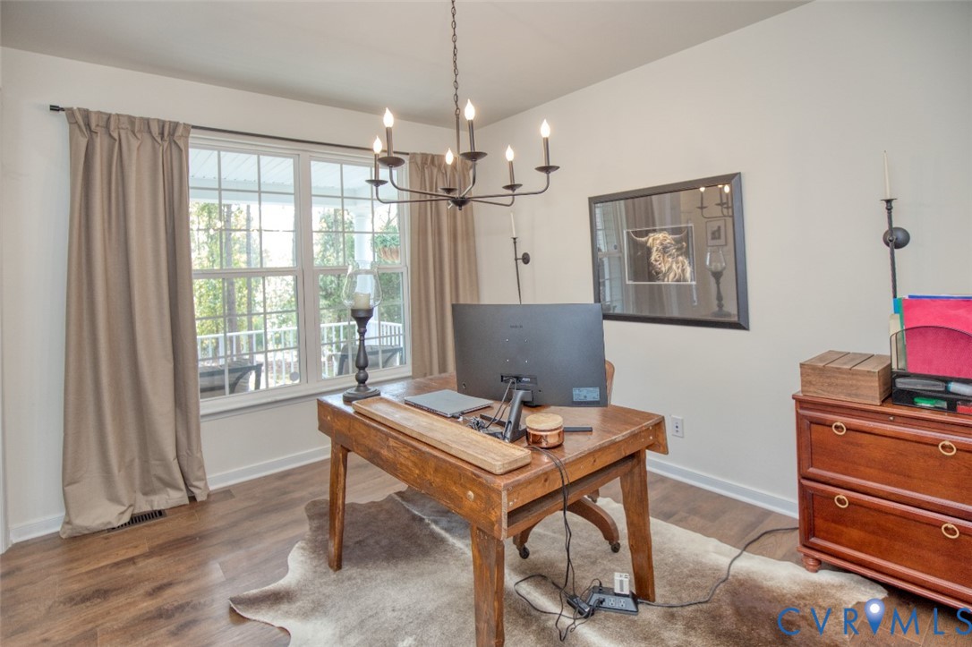 Wood-finish flooring, multi-pane window with grid pattern, and classic black metal chandelier fixture