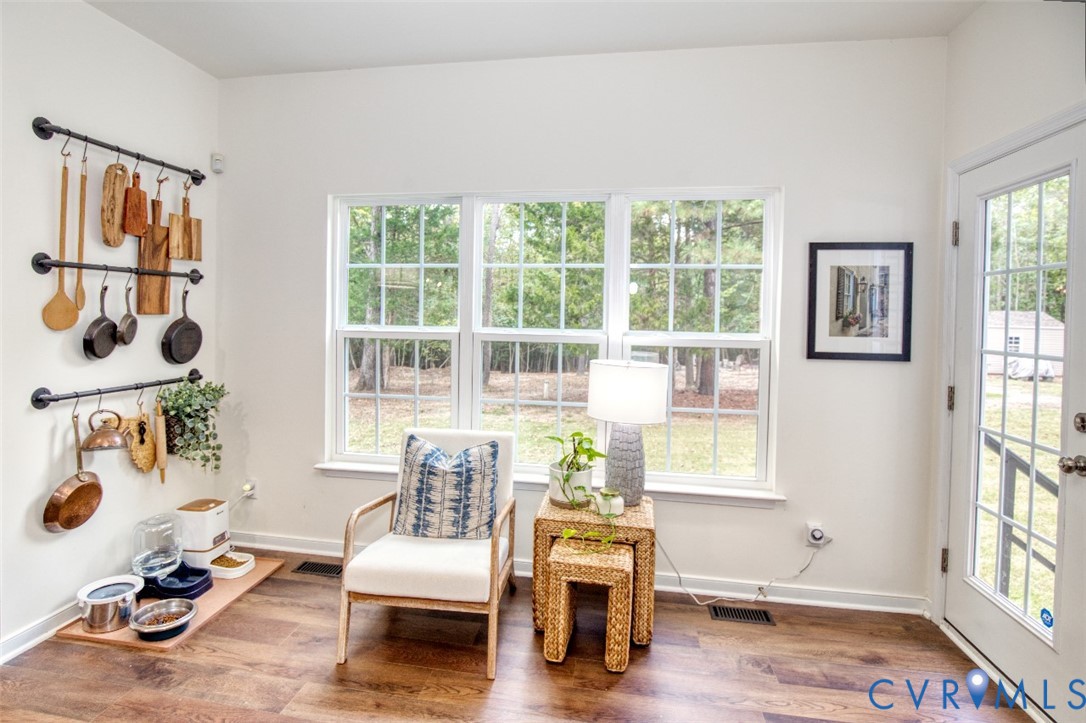 Wall-mounted industrial-style matte black pipe racking, wood-finish flooring, triple-pane window configuration, and a half-light door with integrated window grid