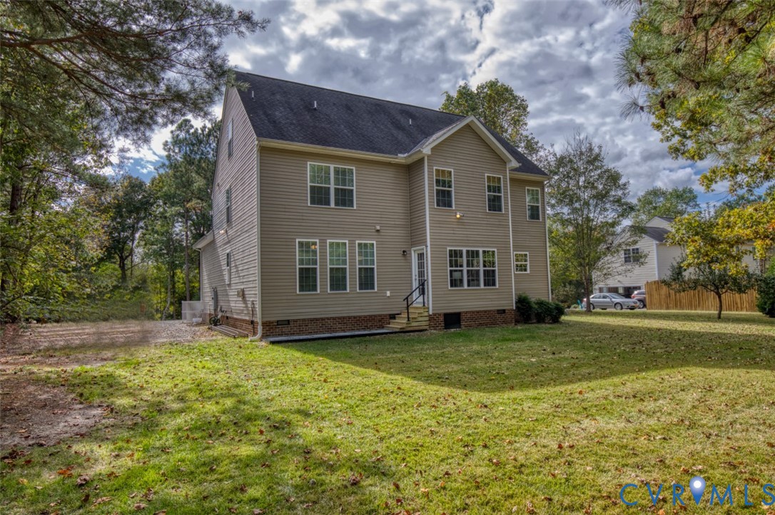 Two-story residence featuring light-toned horizontal siding, a brick foundation perimeter, a shingled roof, and an expansive lawn