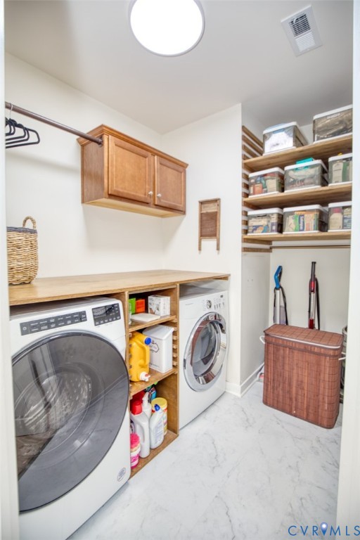 Laundry room featuring stone-finish tile flooring, wood-finish cabinetry, built-in shelving, and a wood-finish countertop