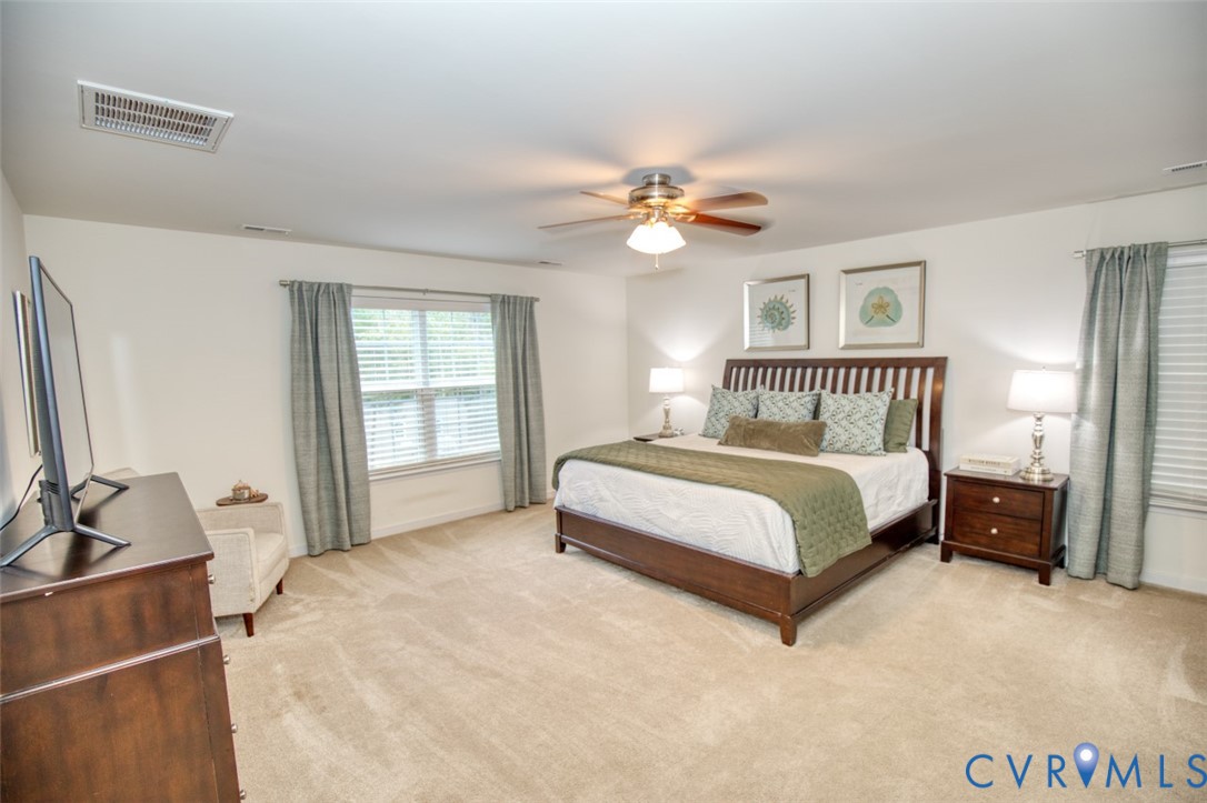 Neutral-toned wall-to-wall carpeting and central ceiling fan with integrated lighting