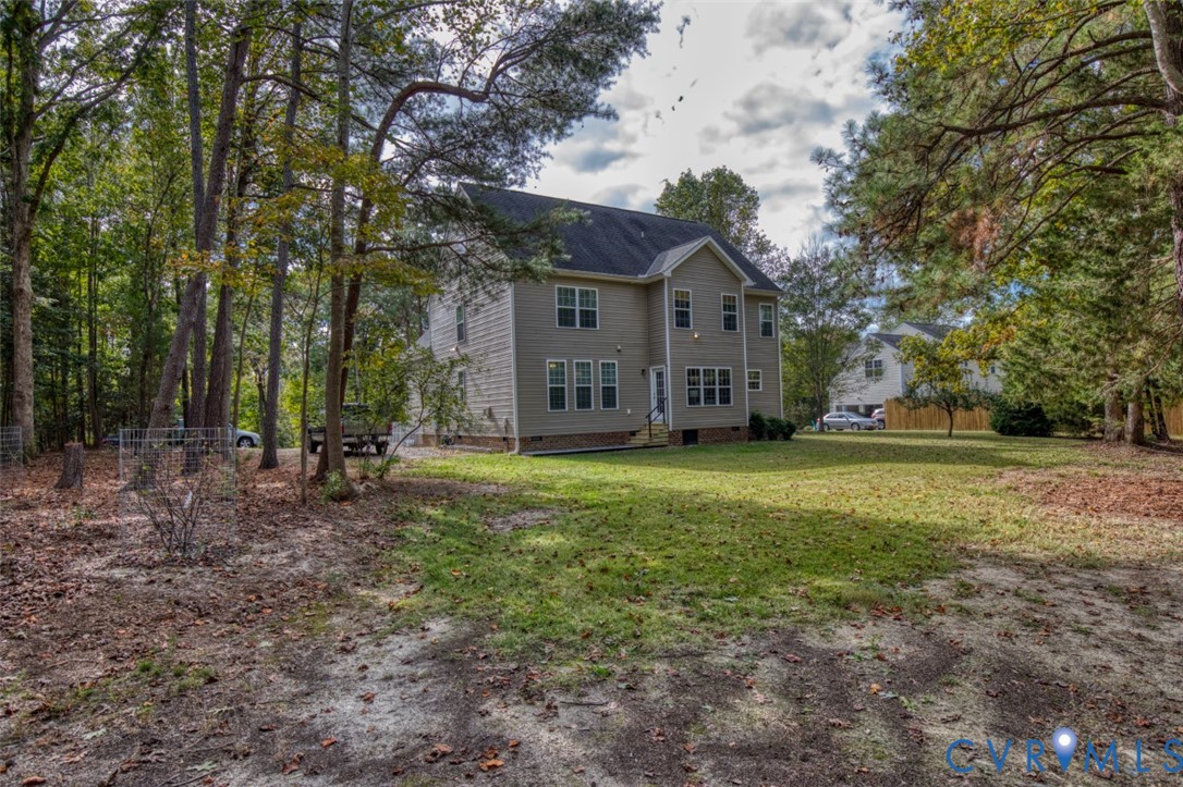 Multi-story exterior featuring light-toned siding, a multi-gabled roofline, double-hung windows, and an expansive wooded lot Multi-story exterior featuring light-toned siding, a multi-gabled roofline, double-hung windows, and an expansive wooded lot