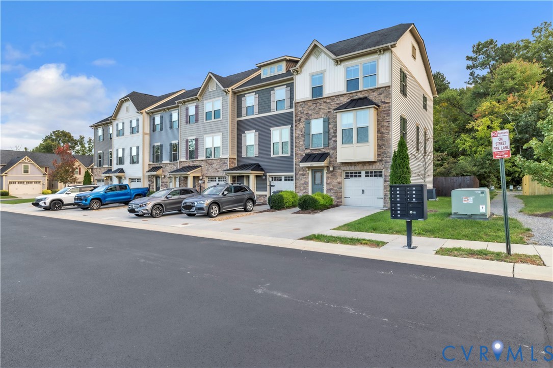 Multi-unit exterior featuring multi-tone siding, stone veneer accents, multi-pane windows, individual garage doors, and pitched shingle roofs Multi-unit exterior featuring multi-tone siding, stone veneer accents, multi-pane windows, individual garage doors, and pitched shingle roofs