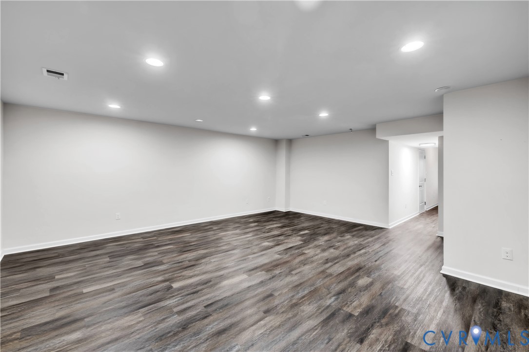 Open-concept interior featuring neutral wall tones, wood-finish flooring, and recessed ceiling lighting
