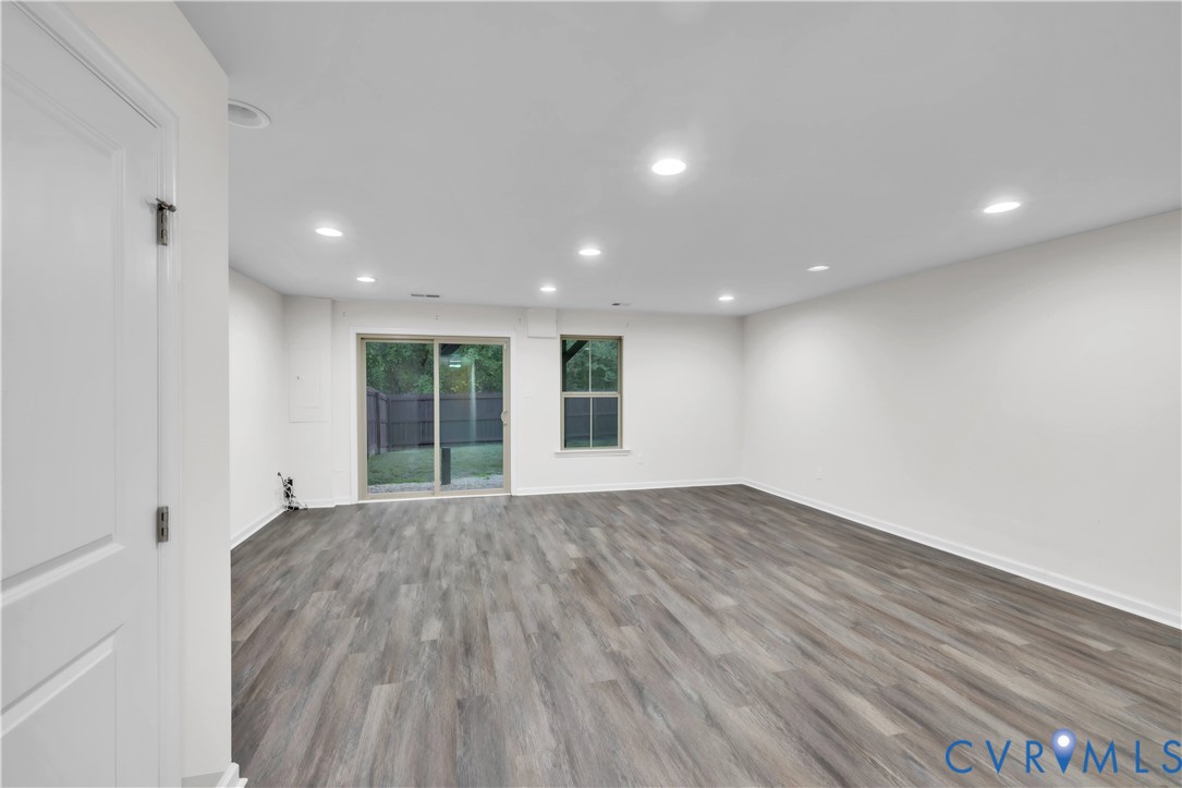 Interior space featuring wood-finish flooring, recessed lighting, a sliding glass door, and a single-pane window