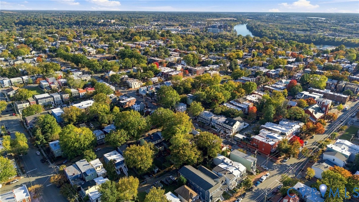 Aerial perspective of the neighborhood featuring established mature trees, high-density residential structures, and proximity to a river