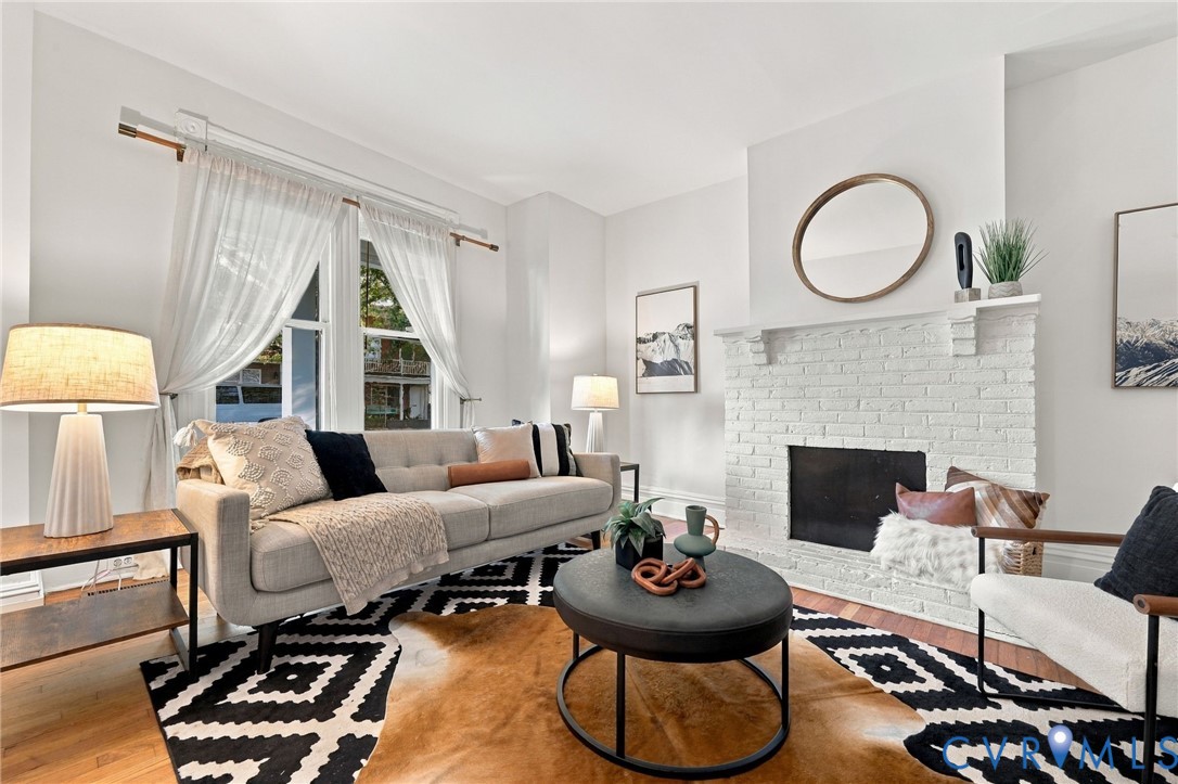 White-painted brick fireplace, dual-pane windows, and wood-finish flooring