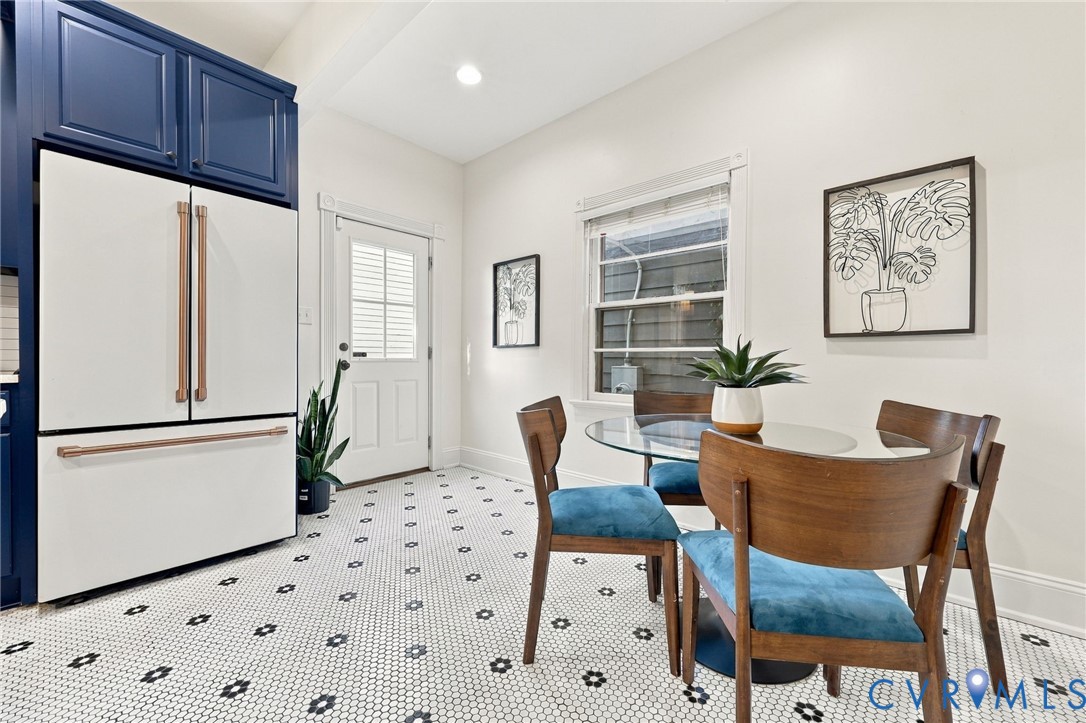 Kitchen featuring custom deep blue cabinetry, a white refrigerator with copper-tone hardware, and geometric patterned tile flooring