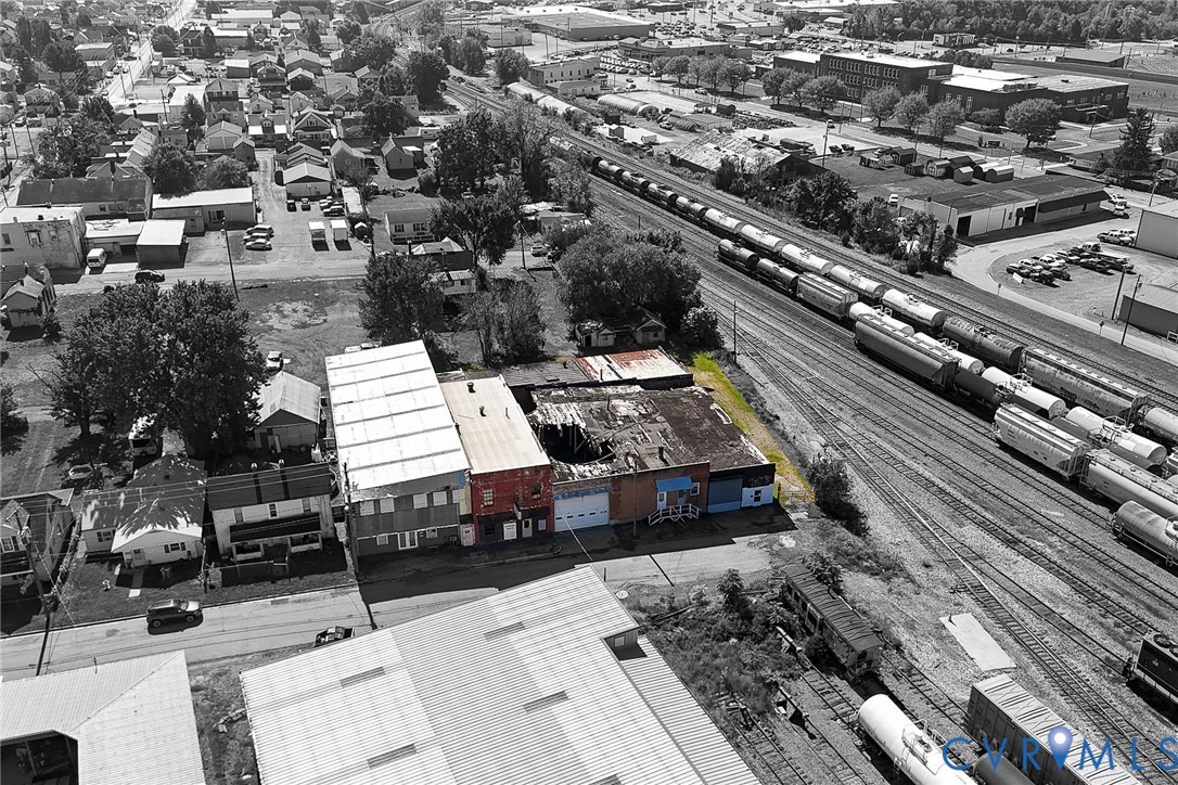 Aerial perspective of a multi-structure commercial site featuring metal and masonry construction, flat roofing systems, and direct street frontage