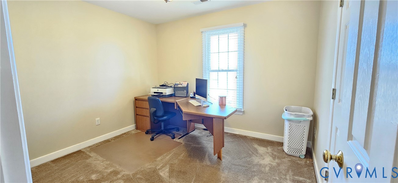Neutral-toned room featuring wall-to-wall carpeting and a multi-pane window with blinds