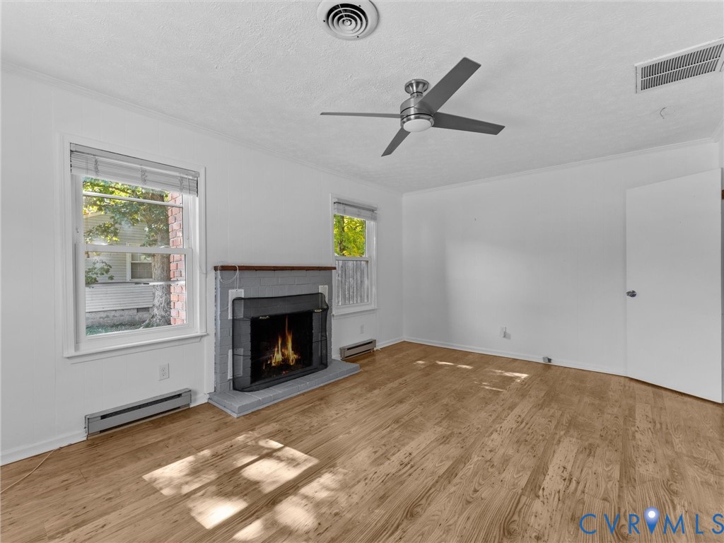 Wood-finish flooring, masonry fireplace with a wood mantel, multi-pane windows, and a ceiling fan