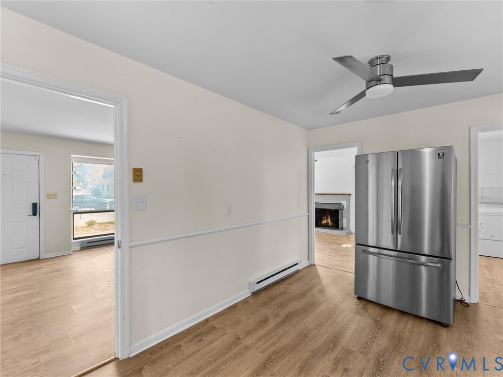 Wood-finish flooring, ceiling fan with integrated lighting, stainless steel French-door refrigerator, and chair rail molding