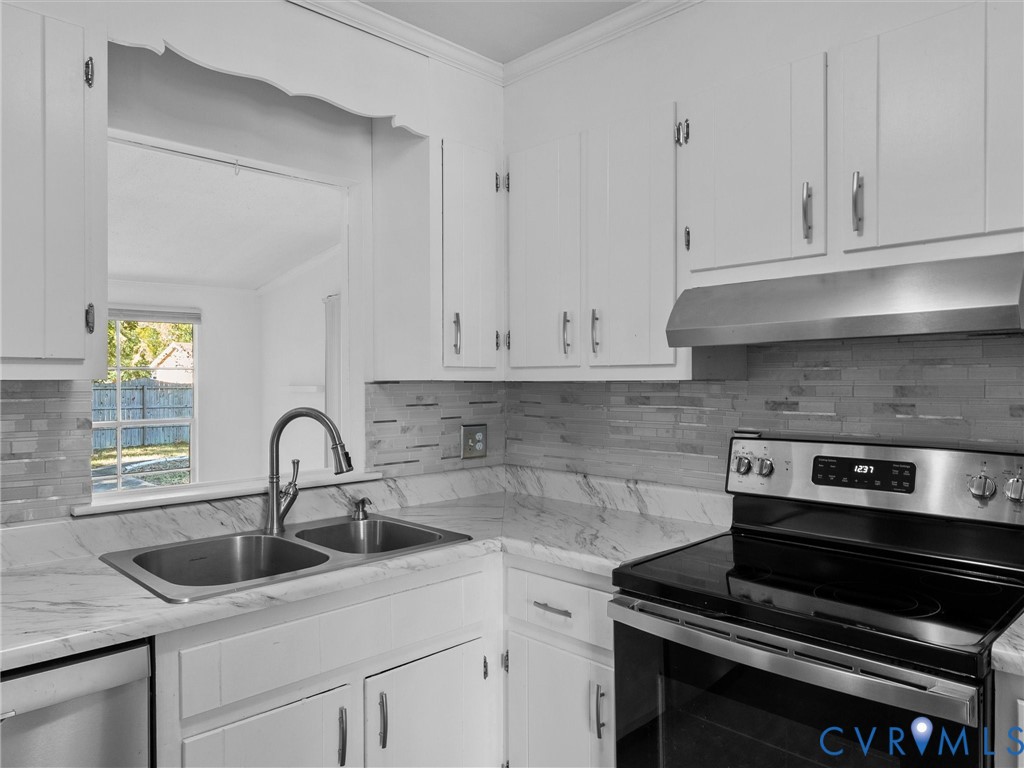 Kitchen featuring white cabinetry, stone-patterned countertops, a stainless steel dual-basin undermount sink with a gooseneck faucet, a subway tile backsplash, and a stainless steel range with a coordinating hood