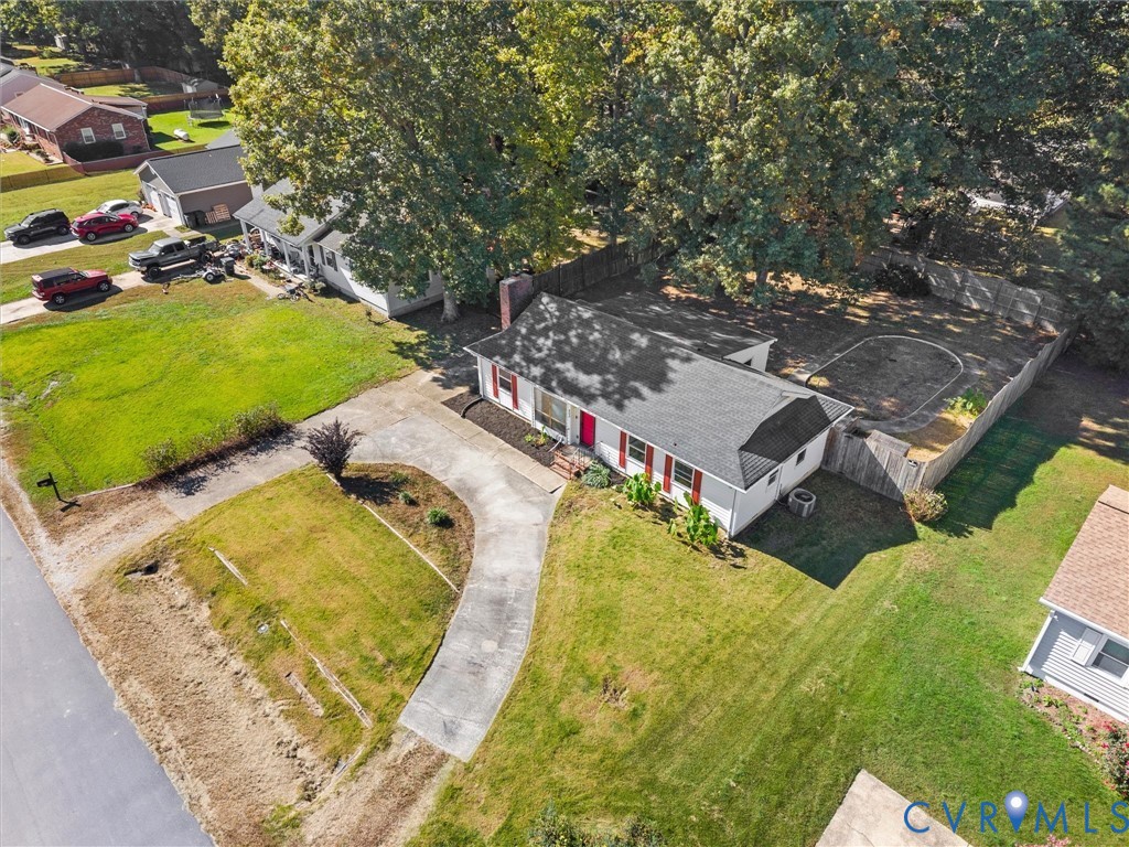 Single-story residence featuring light-colored siding, a pitched roof, a curved concrete driveway, a chimney, and a fenced backyard with mature trees Single-story residence featuring light-colored siding, a pitched roof, a curved concrete driveway, a chimney, and a fenced backyard with mature trees
