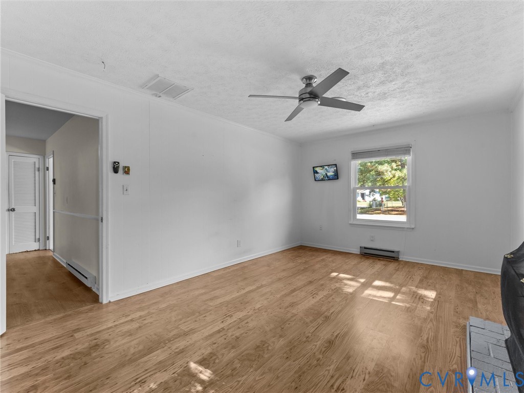 Interior space featuring wood-finish flooring, a ceiling fan, and a single-pane window
